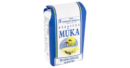 Kúsok chleba s maslom a plátkami, zobrazený na čiernom pozadí, s viditeľnou kôrkou.